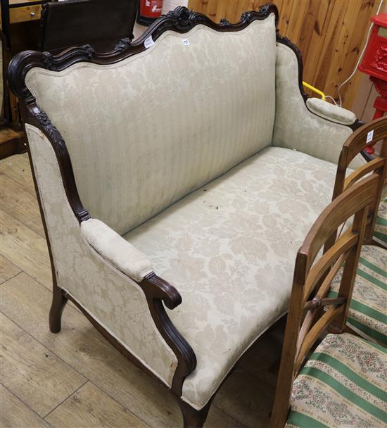 A late Victorian carved mahogany framed settee, on short cabriole legs W.145cm